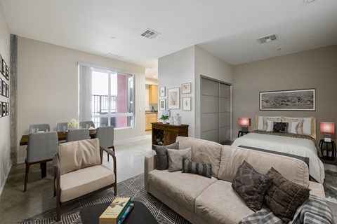 a living room with a couch and a chair and a bed